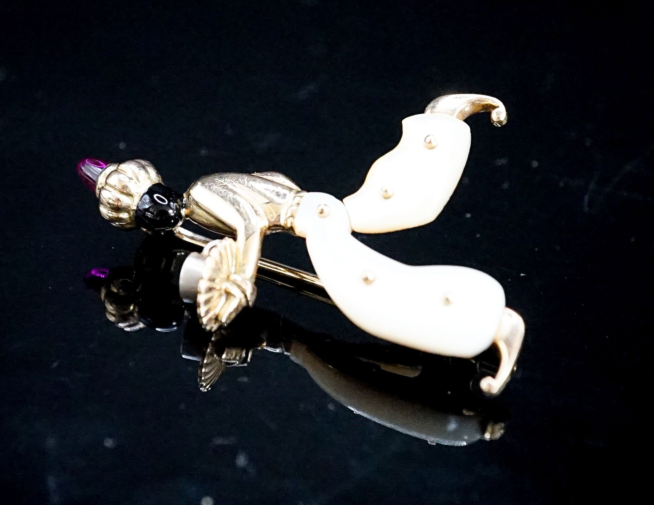 A 20th century Viennese 585 yellow metal, black enamel, mother of pearl and cabochon set brooch, modelled as a Blackamoor, 41mm, gross weight 7.2 grams.